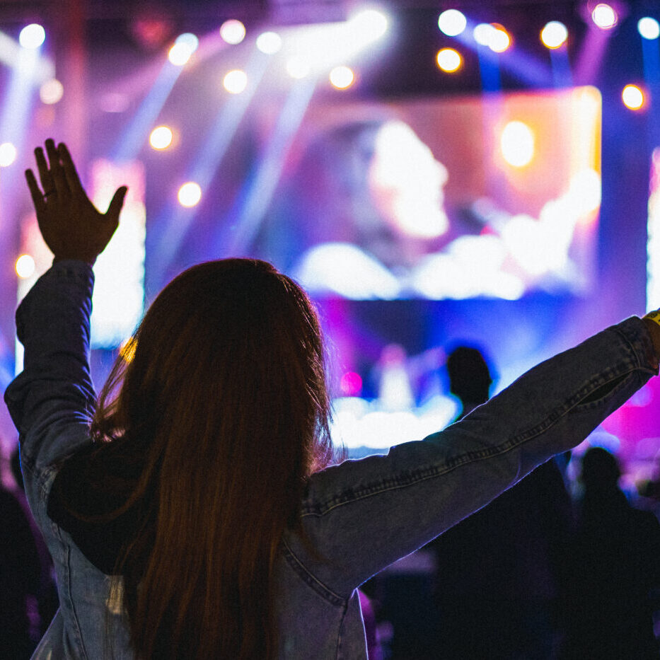 worship concert in a church woman raised hands Worship Concerts