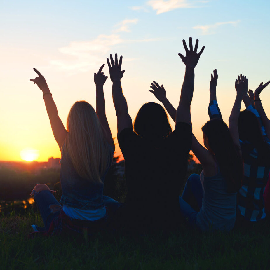 Group of people jumping outdoors; sunset Youth Groups